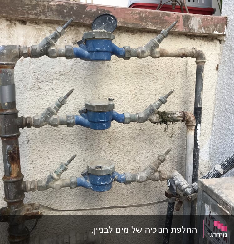 מד מים כחול עם צינורות חלודים וקירות